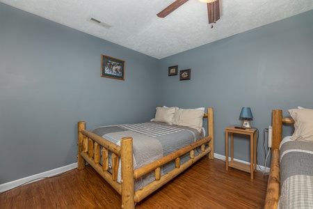 Bedroom with two beds, a table, and lamp at Wildlife Retreat, a 3 bedroom cabin rental located in Pigeon Forge