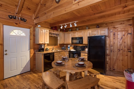 dining table with bench seating for four at always & forever a 1 bedroom cabin rental located in pigeon forge