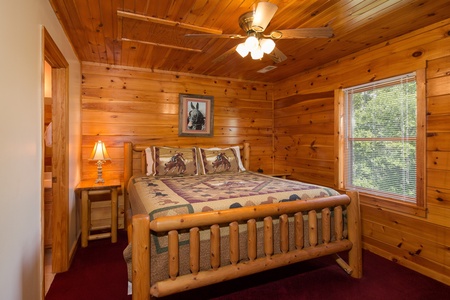 Bedroom with a log bed, night stand, and lamp at Moose Lodge, a 4 bedroom cabin rental located in Sevierville