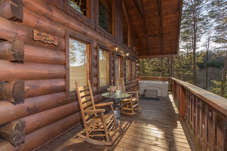 rocking chairs and hot tub on a covered deck at always & forever a 1 bedroom cabin rental located in pigeon forge