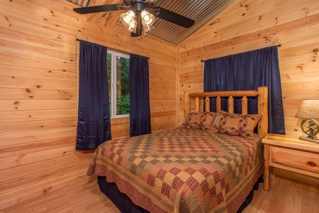 Bedroom with a queen log bed at License to Chill, a 3 bedroom cabin rental located in Gatlinburg