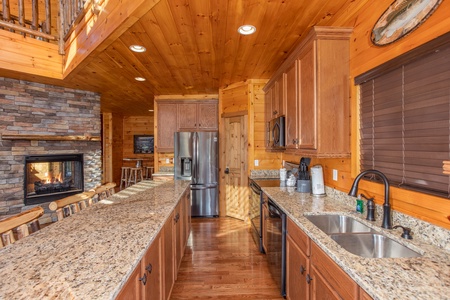 Double-sided fireplace shared with the living room in the kitchen at Four Seasons Palace, a 5-bedroom cabin rental located in Pigeon Forge