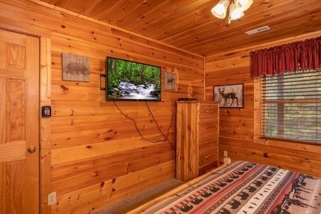 King bedroom with a TV and dresser at Hibernation Station, a 3-bedroom cabin rental located in Pigeon Forge