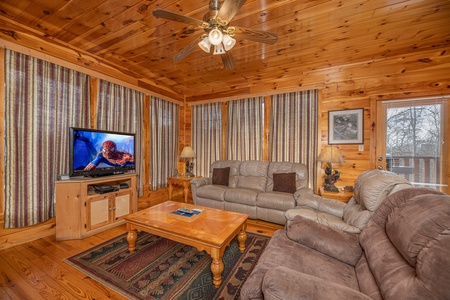 TV and sofas in the living room at Hickernut Lodge, a 5-bedroom cabin rental located in Pigeon Forge