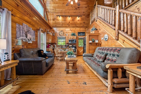 Living room seating, dining space, and kitchen at Honey Bear Haven, a 1 bedroom cabin rental located in Pigeon Forge