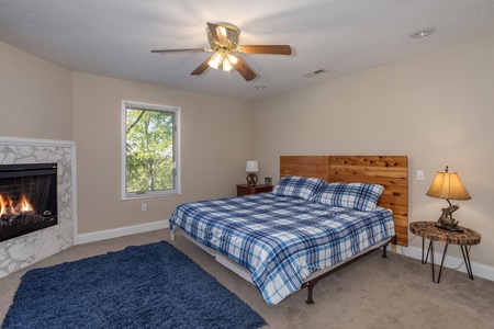 Bedroom with a king sized bed and a fireplace at Into the Woods, a 3 bedroom cabin rental located in Pigeon Forge