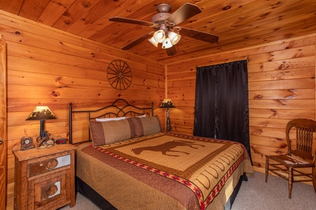 Bedroom with a king-sized bed, two end tables, and a chair at Cabin Fever, a 4-bedroom cabin rental located in Pigeon Forge