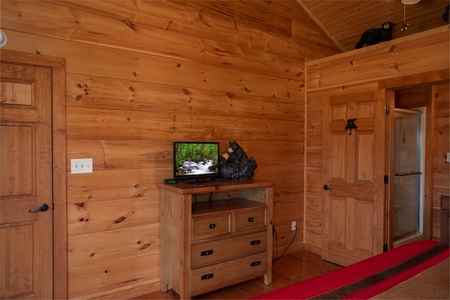 Bedroom with a dresser and television at Cedar Creeks, a 2-bedroom cabin rental located near Douglas Lake