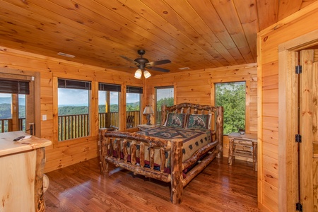 Bedroom with a log bed and deck access at Four Seasons Palace, a 5-bedroom cabin rental located in Pigeon Forge