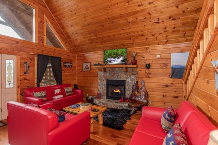 Living room with a sofa, loveseat, chair, fireplace, and Smart TV at Hibernation Station, a 3-bedroom cabin rental located in Pigeon Forge