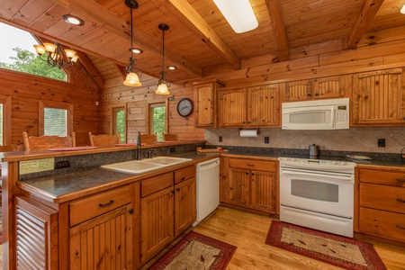 Kitchen with white appliances and breakfast bar at Mountain Lake Getaway, a 3 bedroom cabin rental located at Douglas Lake