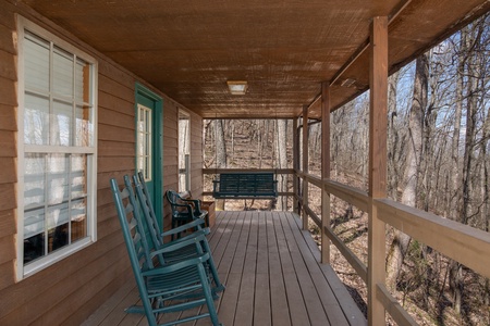 Front deck with rocking chairs and a swing at Hideaway, a 1 bedroom cabin rental located in Pigeon Forge