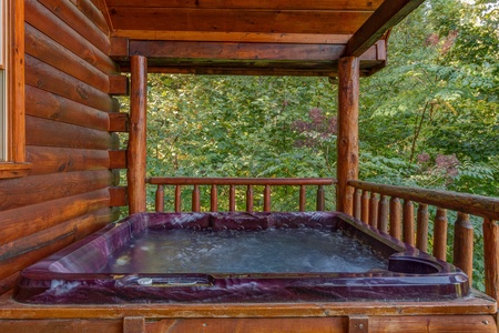 Hot tub on a covered deck at Lincoln Logs, a 2 bedroom cabin rental located in Gatlinburg