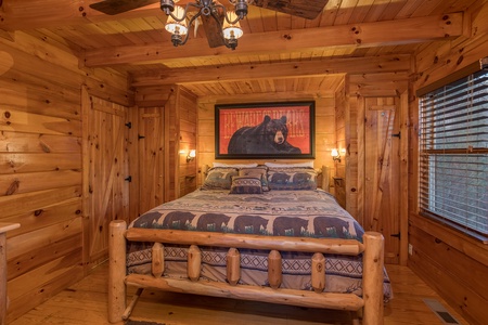 king sized log bed in the master bedroom at always & forever a 1 bedroom cabin rental located in pigeon forge