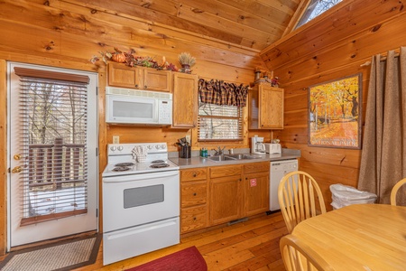 Kitchen with white appliances at Fallin' in Love, a 1 bedroom cabin rental located in Gatlinburg