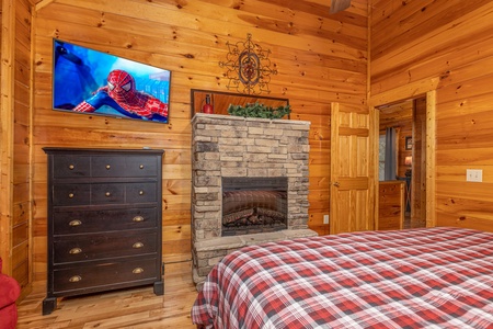 Fireplace, TV, and dresser in a bedroom at Whispering Grace, a 2 bedroom cabin rental located in Gatlinburg