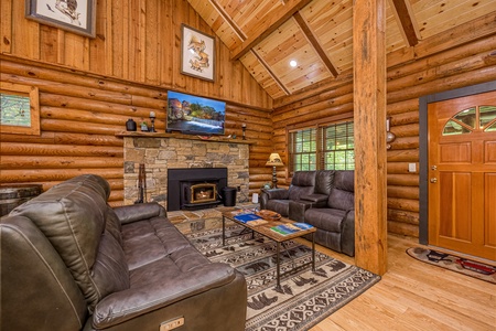 Livingroom with leather couch and loveseat, fireplace, and flat screen at Moonlit Mountain Lodge