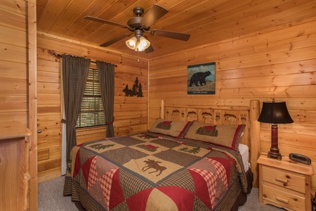 Bedroom with a bed, night stand, and lamp at Kick Back & Relax! A 4 bedroom cabin rental located in Pigeon Forge
