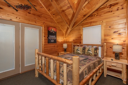Queen log bed on the loft level at Mountain Music, a 5 bedroom cabin rental located in Pigeon Forge