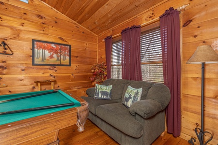 Sofa and pool table in the loft at Fallin' in Love, a 1 bedroom cabin rental located in Gatlinburg