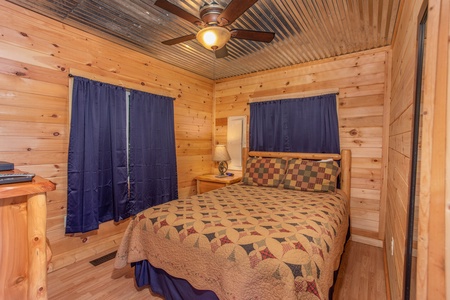 Bedroom with a queen log bed at License to Chill, a 3 bedroom cabin rental located in Gatlinburg