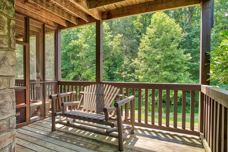 Adirondack bench on a covered porch at Mountain Music, a 5 bedroom cabin rental located in Pigeon Forge