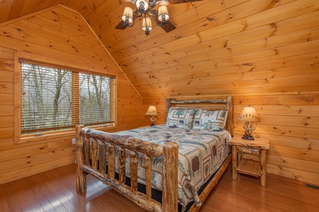 Bedroom with a log bed, two night stands, and two lamps at J's Hideaway, a 4 bedroom cabin rental located in Pigeon Forge
