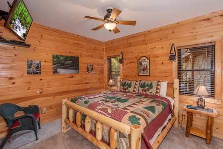 Bedroom with a king-sized log bed and TV at Great View Lodge, a 5-bedroom cabin rental located in Pigeon Forge