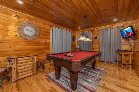 Red felt pool table and TV in a game room at A Bear on the Ridge, a 2 bedroom cabin rental located in Pigeon Forge