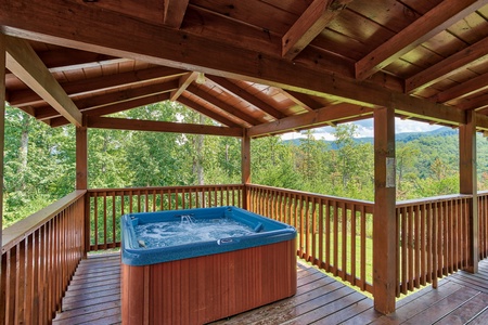 Hot tub on a covered deck at Four Seasons Lodge, a 3-bedroom cabin rental located in Pigeon Forge