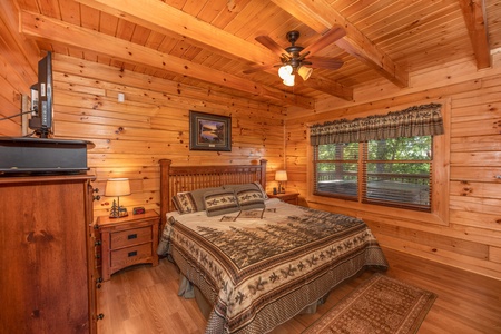 King bedroom with nightstand, dresser, and TV at Grand View, a 3 bedroom cabin rental located in Sevierville