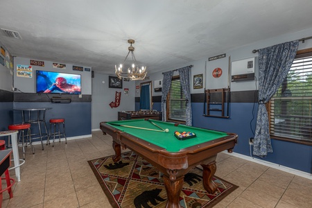 Green felt pool table and TV in a game room at Bearing Views, a 3 bedroom cabin rental located in Pigeon Forge