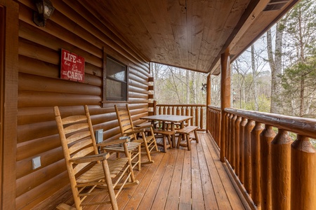 Two rocking chairs and a dining table for four at Whispering Grace, a 2 bedroom cabin rental located in Gatlinburg