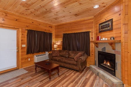 Fireplace and sofa in the lower living room at Starry Starry Night #725, a 2 bedroom cabin rental located in Pigeon Forge