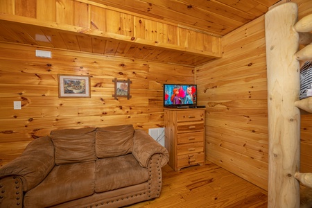 Sofa & Dresser with TV at Hickernut Lodge, a 5-bedroom cabin rental located in Pigeon Forge