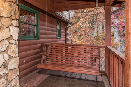 Porch swing on a covered deck at Just for Fun, a 4 bedroom cabin rental located in Pigeon Forge