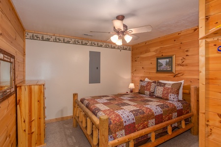 Queen-sized log bed at Bearly in the Mountains, a 5-bedroom cabin rental located in Pigeon Forge