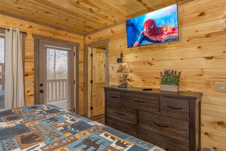 Dresser, TV, and deck access at Everly's Splash, a 4 bedroom cabin rental located in Pigeon Forge