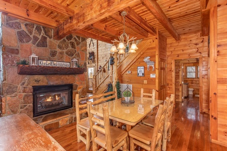 Dining room table with seating for six next to the fireplace at The Original American Dream, a 2 bedroom cabin rental located in Gatlinburg