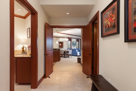 - Inviting hallway with double doors opening to the bright and spacious living area - Warm wood trim and neutral flooring create a welcoming transition between rooms - Thoughtful layout connects private spaces to shared gathering areas