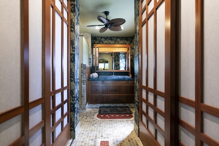 Bathroom entry with patterned tile floor and wood sliding doors.
