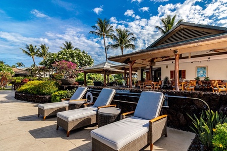 Poolside loungers and shaded seating near the open air dining area.