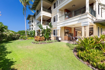 Ground floor patio opening to a manicured lawn and tropical landscaping.