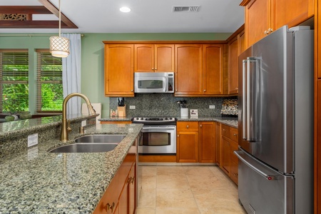 - Bright kitchen featuring granite counters, stainless steel appliances, and plenty of storage - Warm wood cabinetry complements the sleek modern design - Double sink and open layout make cooking and cleanup a breeze