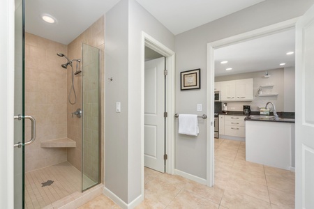 - Bathroom features a tiled walk in shower with built in bench and sleek fixtures - Convenient layout with hallway access and views into the modern kitchen - Perfect for refreshing after beach outings or morning workouts
