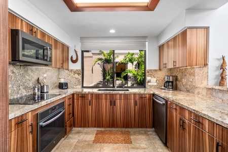 Your gourmet kitchen features warm wood cabinetry, granite countertops, and modern appliances - perfect for preparing memorable meals during your stay.