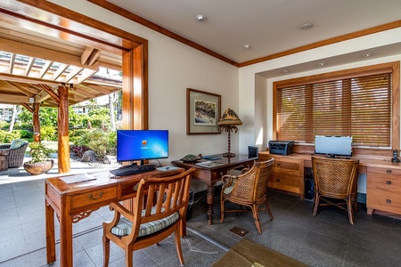 Business center with computers, printer, and garden views through open doors.