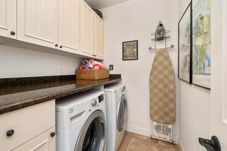 - Full laundry room with modern washer, dryer, and granite countertop - Plenty of cabinet storage and space for folding and sorting essentials - Includes ironing board, iron, and basket stocked with fresh towels