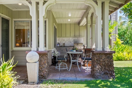 Covered lanai with garden views, dining table, and BBQ