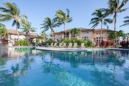 Lagoon style pool with palm trees and sun loungers for a relaxing day.